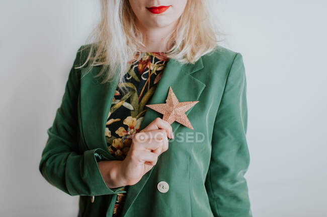 Woman holding Christmas star decoration against her chest — Stock Photo