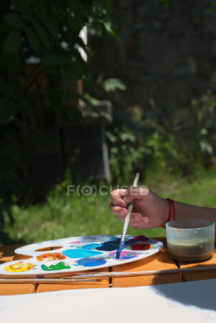 Girl sitting in the garden painting with watercolor paint — Stock Photo