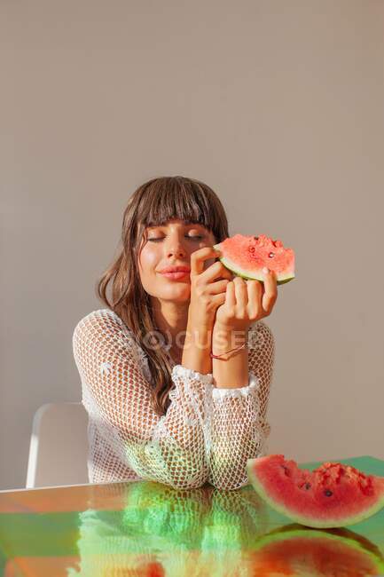 Femme souriante tenant une tranche de pastèque — Photo de stock