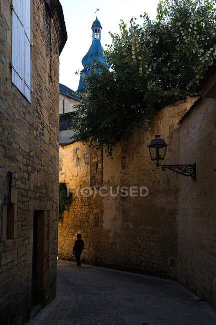 Frau läuft eine enge Straße in Sarlat-la-Caneda, Dordogne, Frankreich — Stockfoto