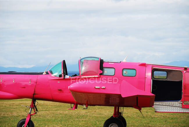 Pink skydiving plane in a field, New Zealand — Stock Photo