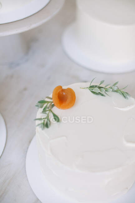 Close-up de um bolo com cobertura de creme de manteiga e decoração de pêssego — Fotografia de Stock