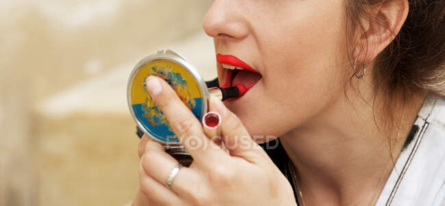 Retrato de mujer aplicando lápiz labial - foto de stock
