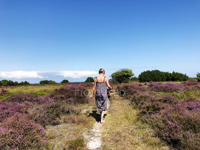Mujer llevando una toalla y caminando a la playa, Samsoe, Dinamarca - foto de stock