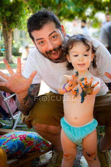 Батько і дочка малюють рукою і тягнуть смішні обличчя — стокове фото