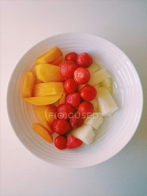 Bowl of strawberries, melon and mango — Stock Photo