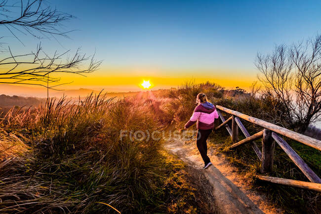 Mulher caminhando ao longo do caminho no belo pôr do sol cena, Itália — Fotografia de Stock