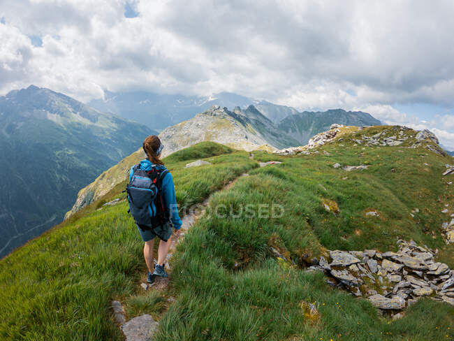 Mulher em roupas esportivas caminhadas na bela paisagem montanhosa — Fotografia de Stock