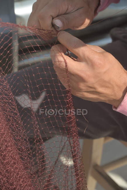 Nahaufnahme eines Fischers, der ein Fischernetz repariert, Griechenland — Stockfoto