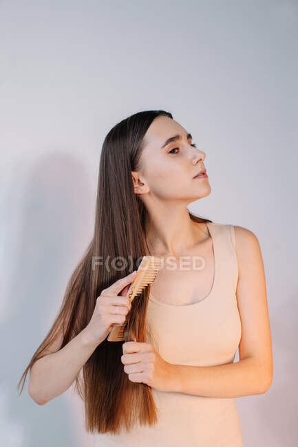 Mulher penteando seu cabelo longo — Fotografia de Stock