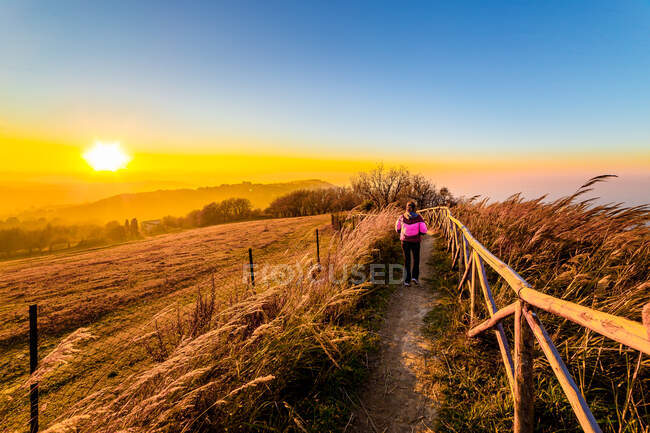 Жінка йде стежкою на прекрасній заході сонця, Італія. — стокове фото