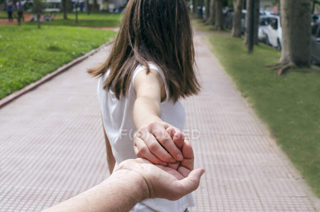 Visão traseira de uma menina segurando a mão de seu pai — Fotografia de Stock