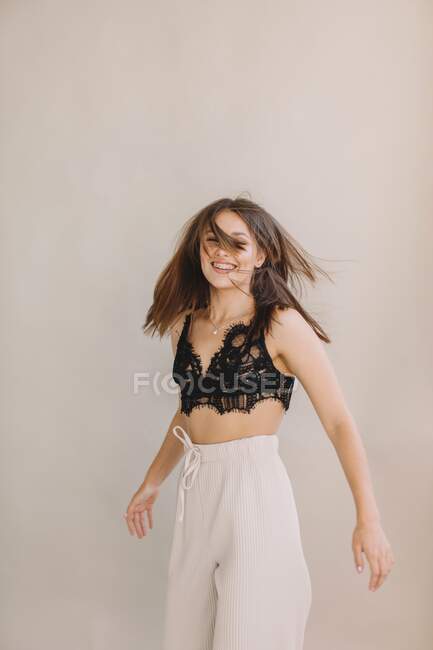 Mujer sonriente lanzando su pelo sobre fondo blanco - foto de stock