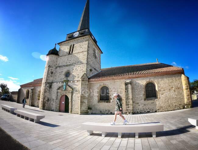 Girl walking on a bench by a church, Saint Jean de Monts, Vendee, France — Stock Photo