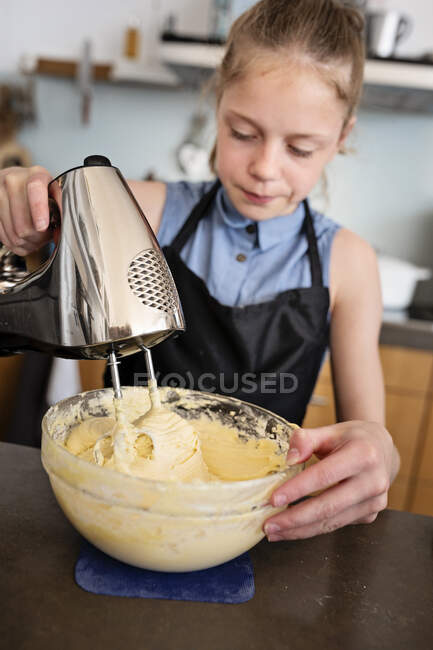 Mädchen steht in der Küche und backt einen Kuchen — Stockfoto