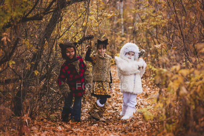 Tres niños en el bosque disfrazados para Halloween, Estados Unidos - foto de stock