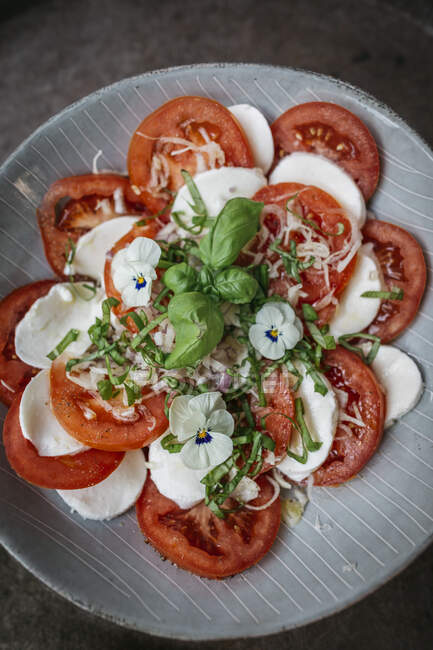 Insalata di mozzarella, pomodoro e basilico con viole commestibili — Foto stock