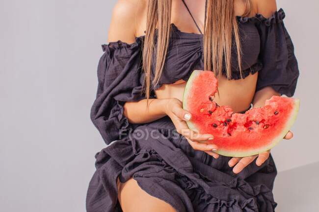 Gros plan d'une femme tenant une tranche de pastèque — Photo de stock