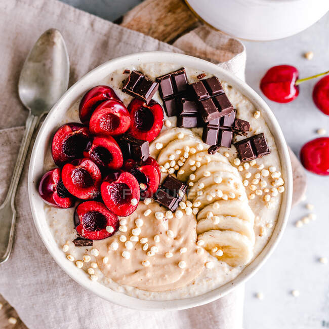 Vanilla oatmeal with cashew butter, banana, cherries and chocolate — Stock Photo