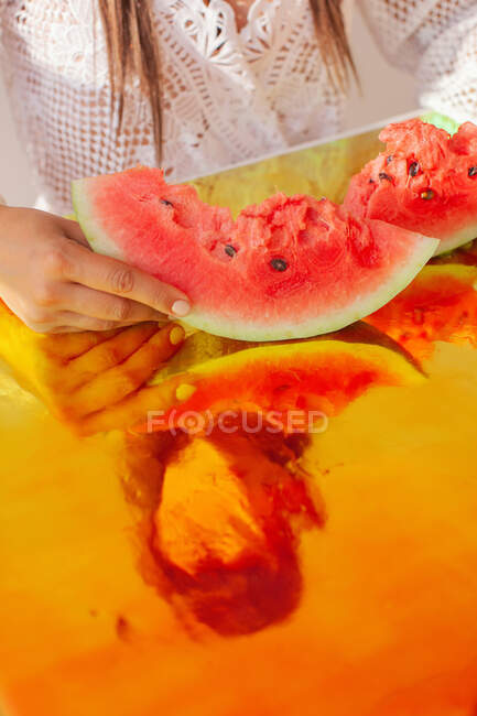 Mulher segurando fatias de melancia na folha holográfica — Fotografia de Stock