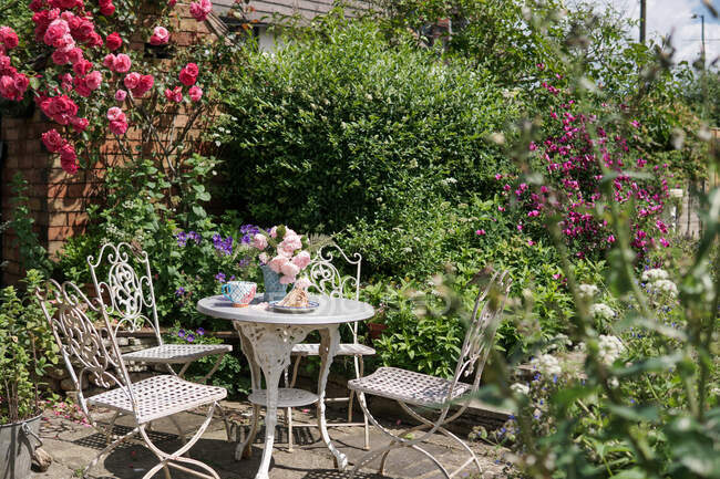 Té y pastel en un jardín de rosas Inglés en el verano, Inglaterra, Reino Unido - foto de stock