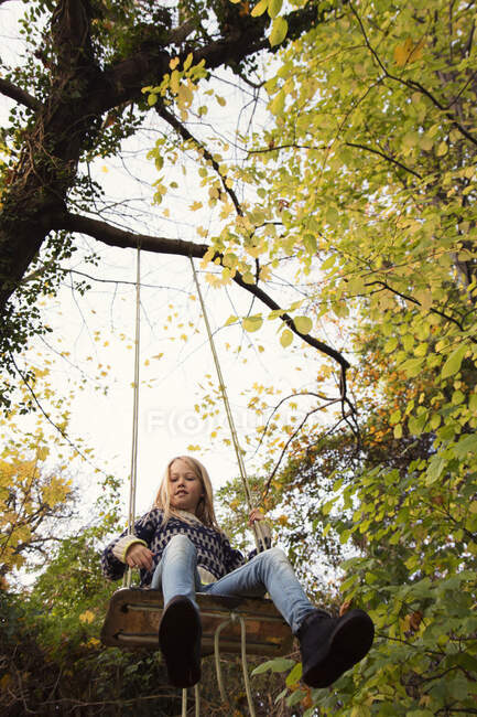 Boy sitting on a swing in the garden, Denmark — Foto stock