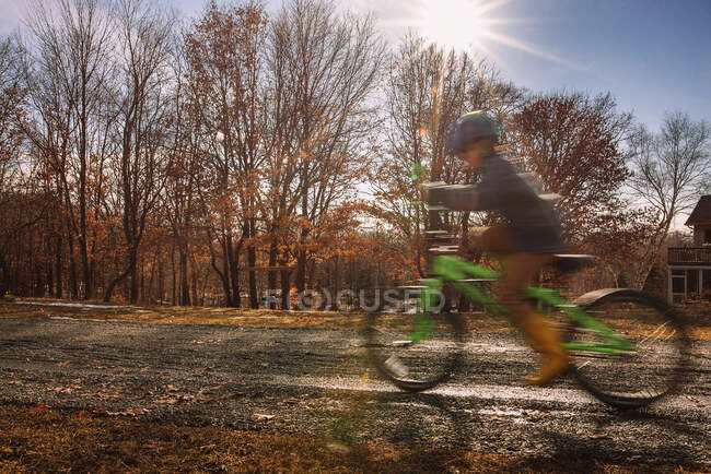 Boy riding a bicycle outside his house, USA — Stock Photo