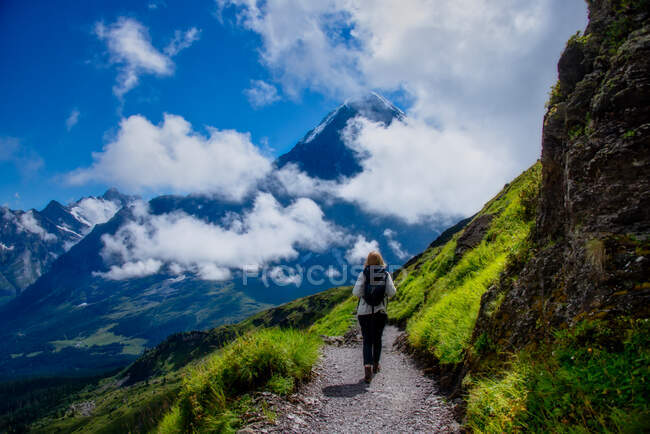 Mulher caminhando ao longo de um caminho alpino, Suíça — Fotografia de Stock