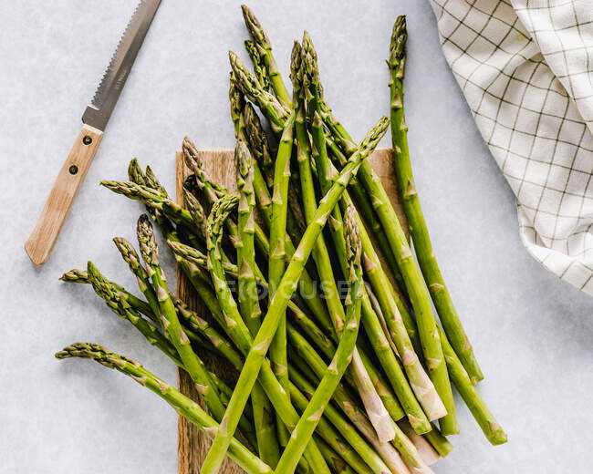 Green asparagus on a wooden chopping board — Stock Photo