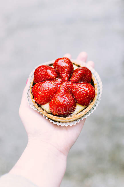 Woman holding strawberry tart — Stock Photo