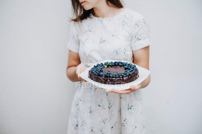 Жінка тримає шоколадний пиріг з чорниці. — стокове фото