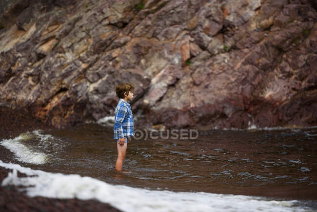 Мальчик, стоящий в реке, Соединенные Штаты — стоковое фото
