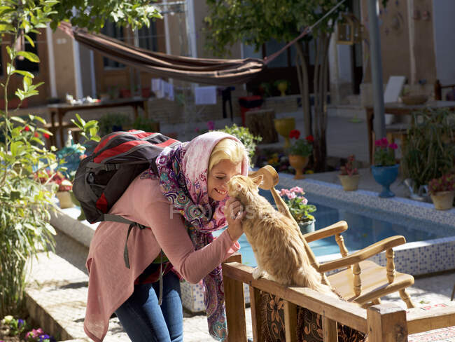 Mujer acariciando a un gato en la calle, Irán - foto de stock