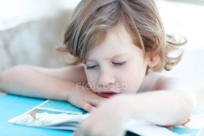 Retrato de un niño leyendo un libro - foto de stock