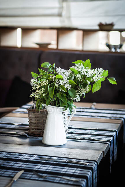 Flores lilás brancas em uma mesa de jantar — Fotografia de Stock