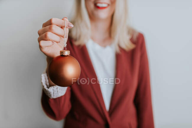 Ritagliato colpo di donna sorridente tenendo bauble Natale — Foto stock
