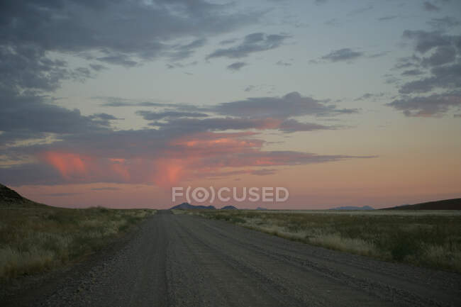 Schotterpiste durch die Wüste bei Sonnenuntergang, Namibia — Stockfoto