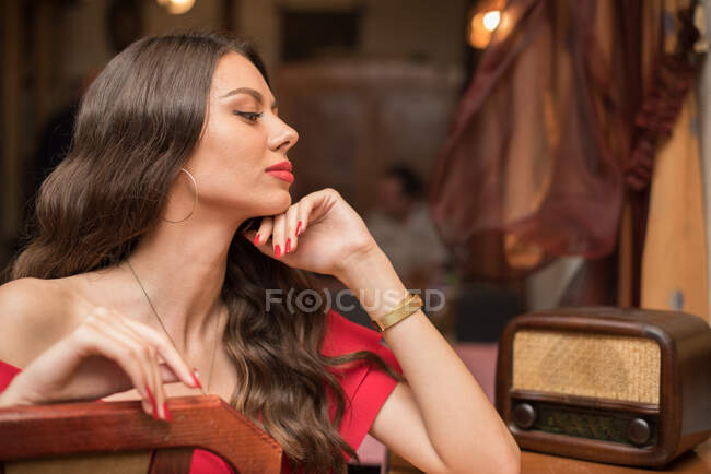 Retrato de uma mulher elegante sentada ao lado de um rádio — Fotografia de Stock
