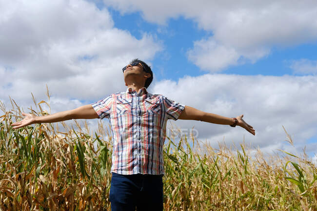 Человек, стоящий в поле с распростертыми руками, Франция — стоковое фото