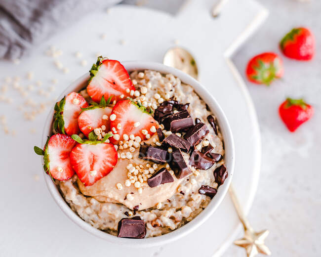 Oatmeal bowl with strawberries, peanut butter, chocolate and puffed rice — Stock Photo