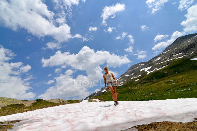 Woman standing on a patch of snow in the mountains, Oberaar, Switzerland — Stock Photo