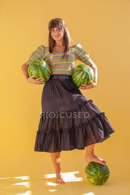 Mulher sorridente segurando melancias — Fotografia de Stock