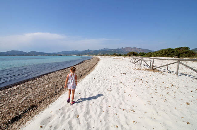 Fille marchant le long de la plage de La Cinta, San Teodoro, Sardaigne, Italie — Photo de stock