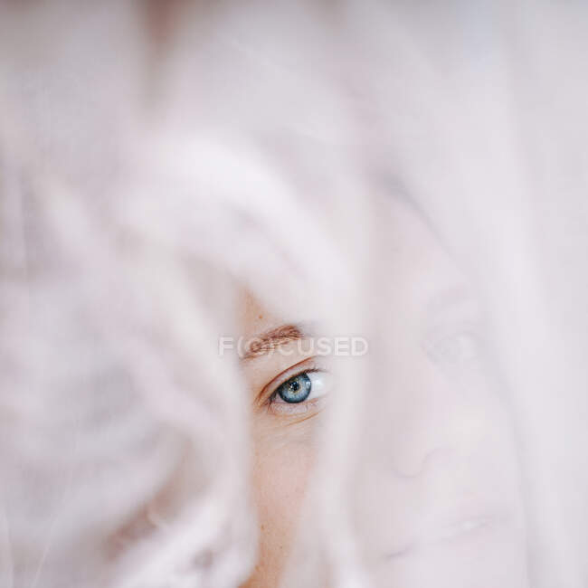 Портрет женщины, смотрящей сквозь кружевную вуаль — стоковое фото