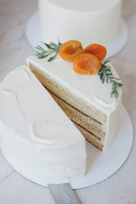 Cake with buttercream icing and fruit sliced in half — Stock Photo