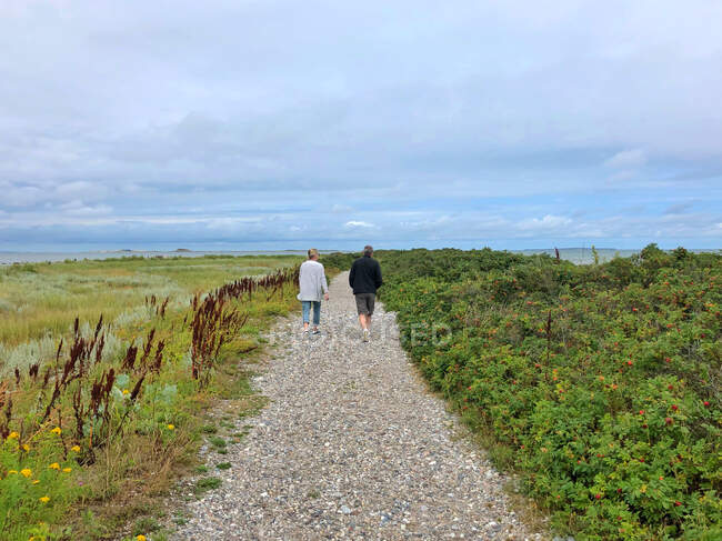 Couple marchant le long de la plage, Besser Rev, Samsoe, Danemark — Photo de stock