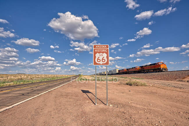 Tren que conduce más allá de una señal histórica de la ruta 66 cerca de Seligman, Arizona, Estados Unidos - foto de stock