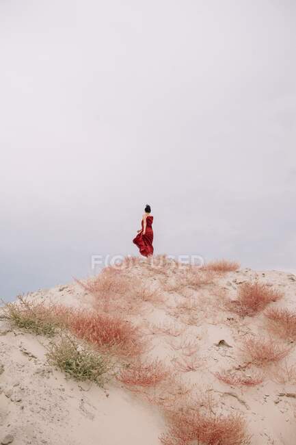 Woman standing on top of a sand dune in the desert, Russia — Stock Photo
