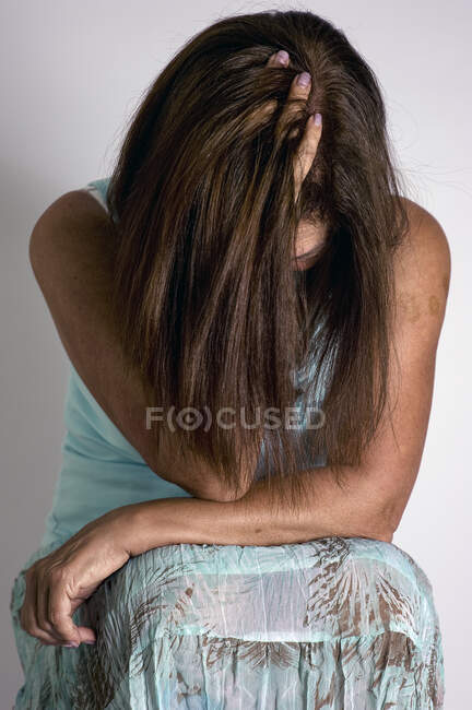 Retrato de una mujer con la cabeza en las manos - foto de stock