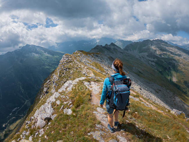 Mujer en ropa deportiva senderismo en hermoso paisaje montañoso - foto de stock